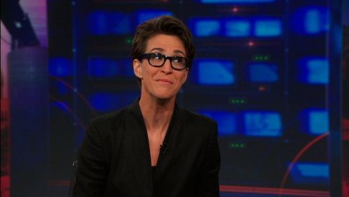 Rachel Maddow, una presentadora de noticias lesbiana con gafas con montura de concha, hace una mueca mientras aparece en "The Daily Show"