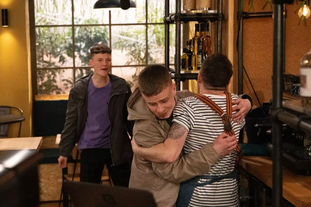 Image shows the moment in the fight where Samson is accidentally stabbed by Matty. Matty is facing away from the camera and Samson is facing towards it. Josh is in the background.