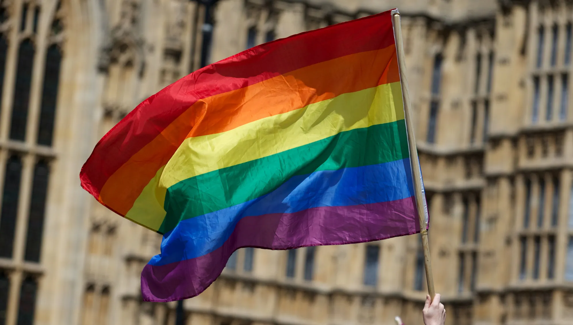 An LGBTQ+ pride flag flying outside parliament
