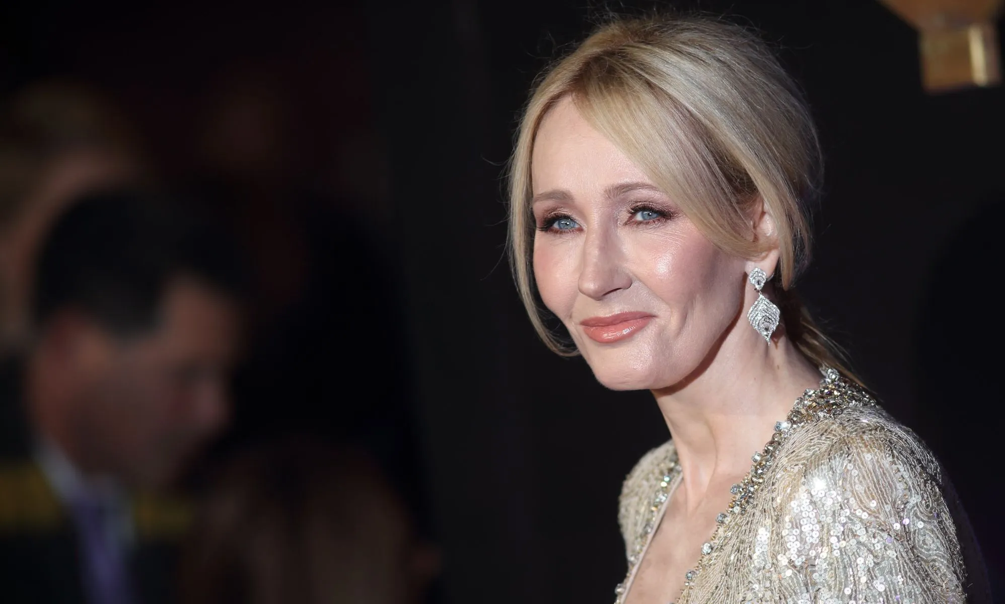 Harry Potter author JK Rowling wears a gold, glittery outfit as she poses for the camera