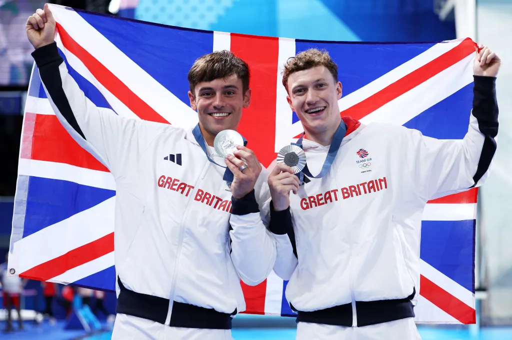 Los medallistas de plata Thomas Daley y Noah Williams del equipo de Gran Bretaña posan con la bandera nacional del equipo de Gran Bretaña.