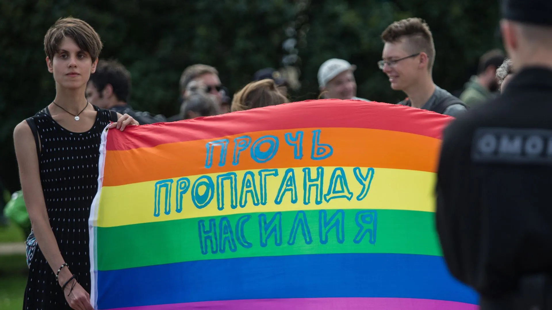 A participant holds a banner with the inscription