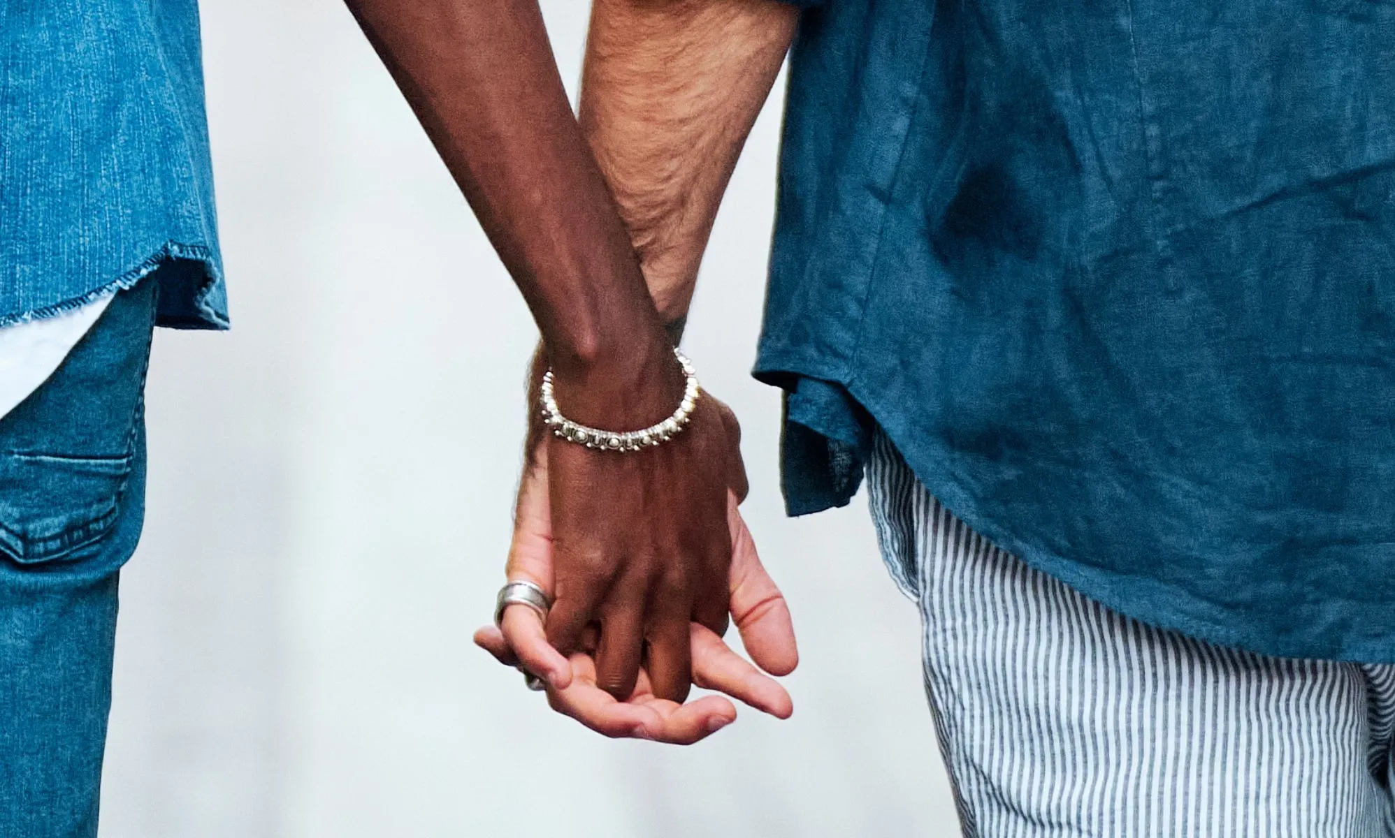 Two men hold hands in public.