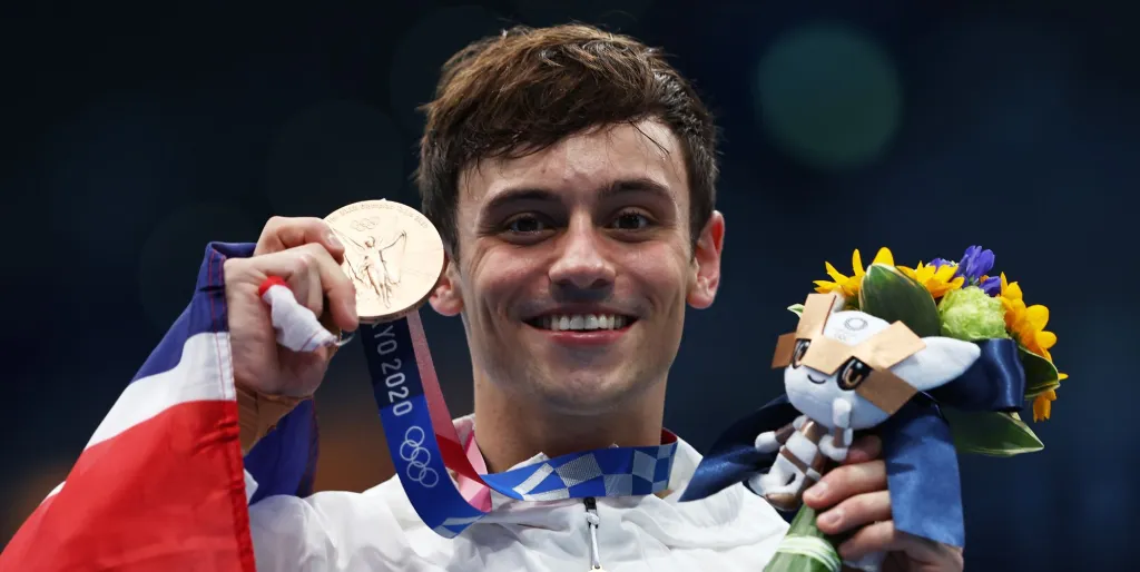 Tom Daley sostiene su medalla