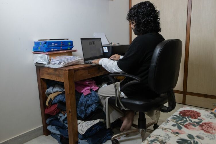 Dee trabaja en su computadora portátil y administra pedidos en línea desde su habitación.