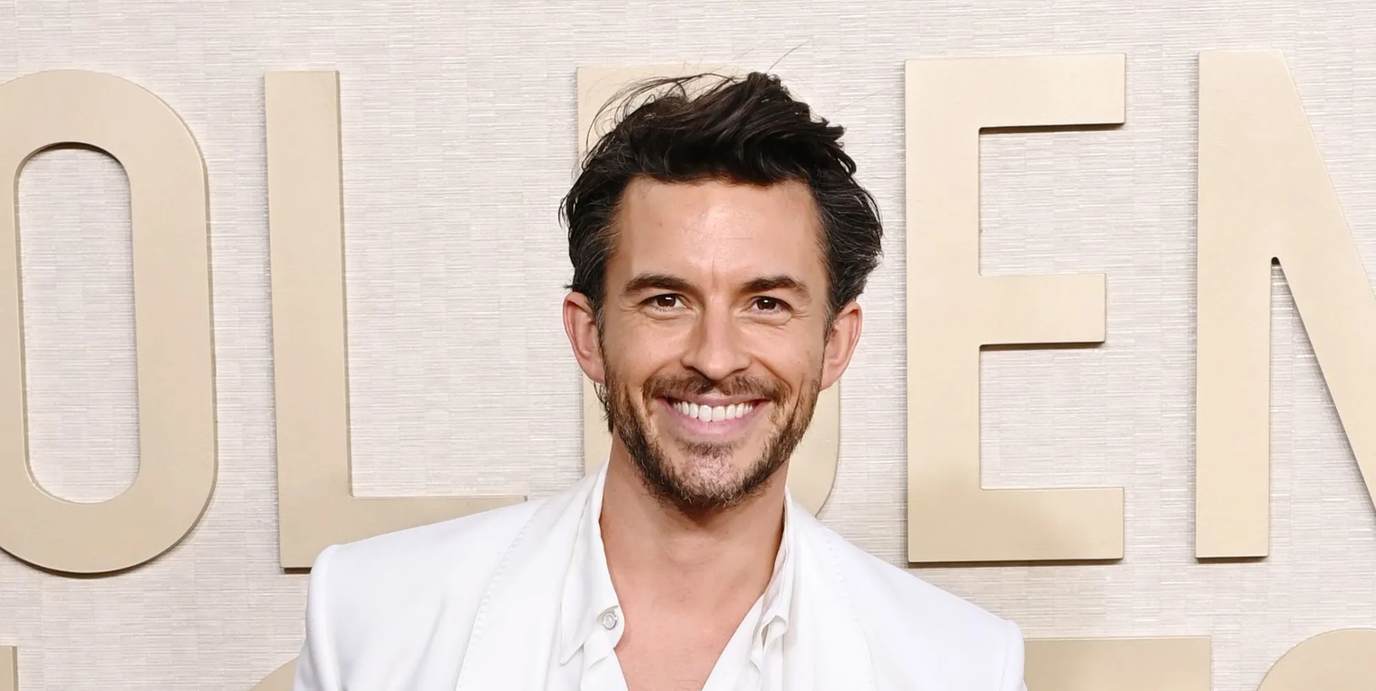 Jonathan Bailey on a white suit smiling