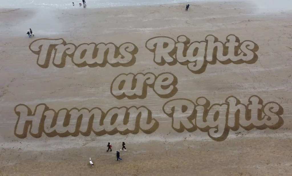 A sand mural that reads: