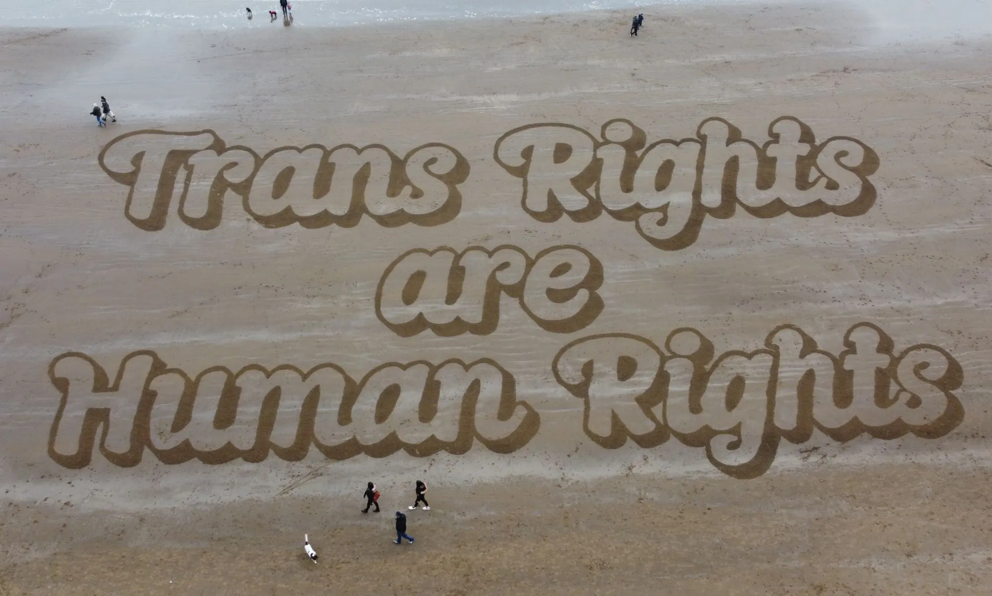 A sand mural that reads: