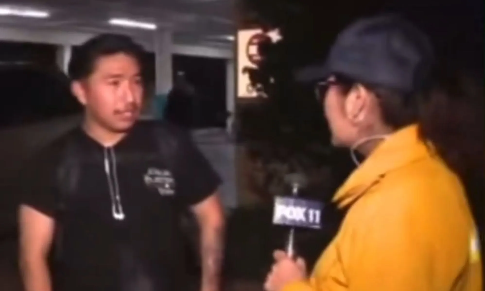 A screenshot of a man speaking to a news reporter in a yellow jacket.
