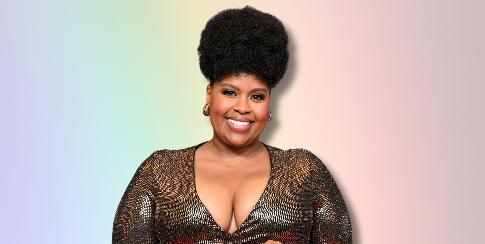 The White Lotus star Natasha Rothwell smiles against a rainbow background.