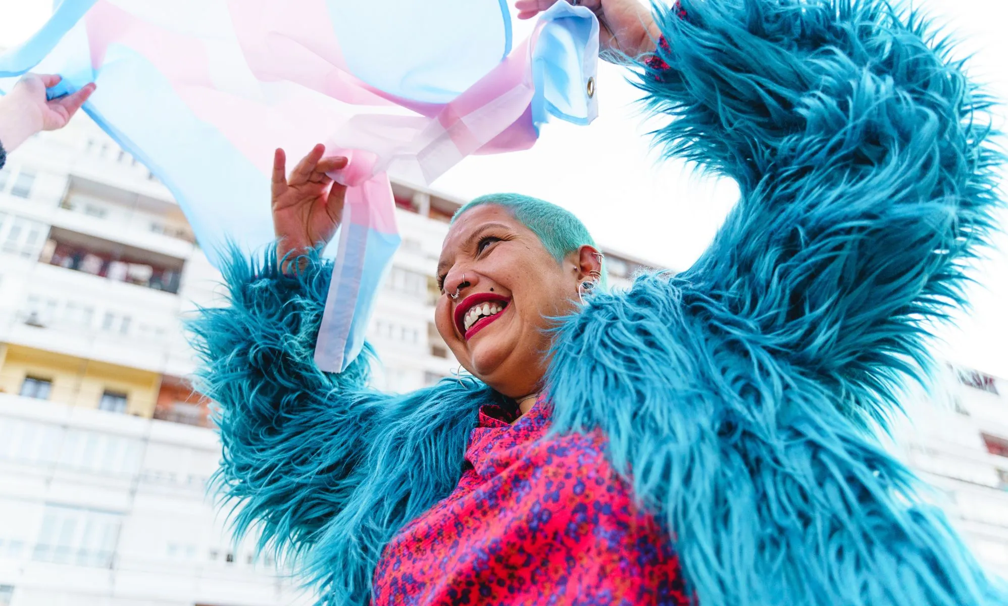 A person happily waving a trans flag.