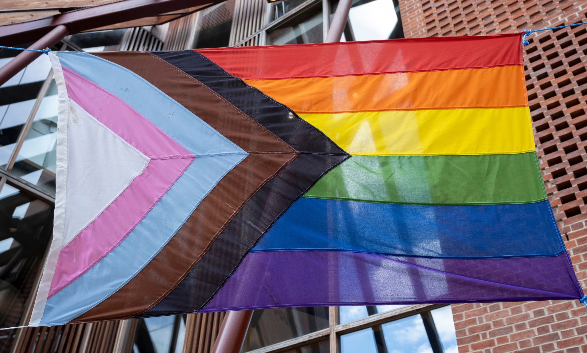 A Pride flag hung on a street.