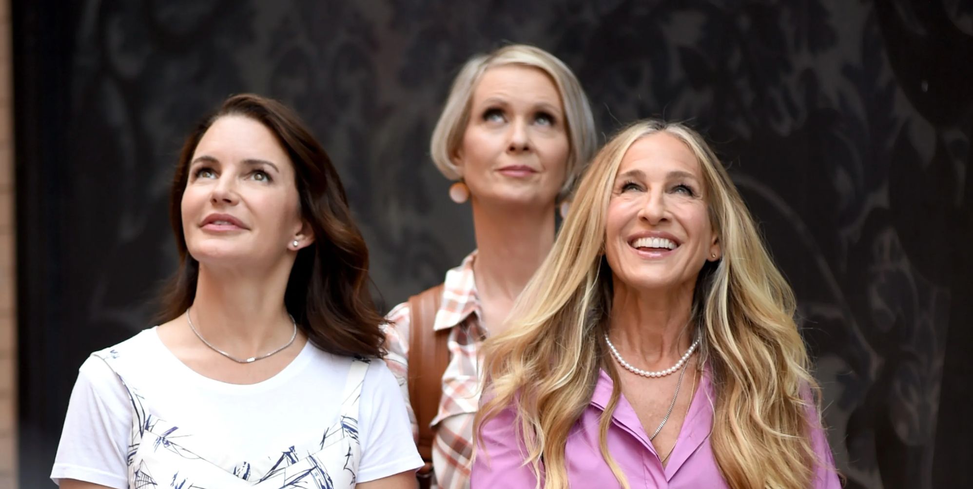 Kristin Davis, Cynthia Nixon and Sarah Jessica Parker look up as they are in character as Charlotte York Goldenblatt, Miranda Hobbes and Carrie Bradshaw.