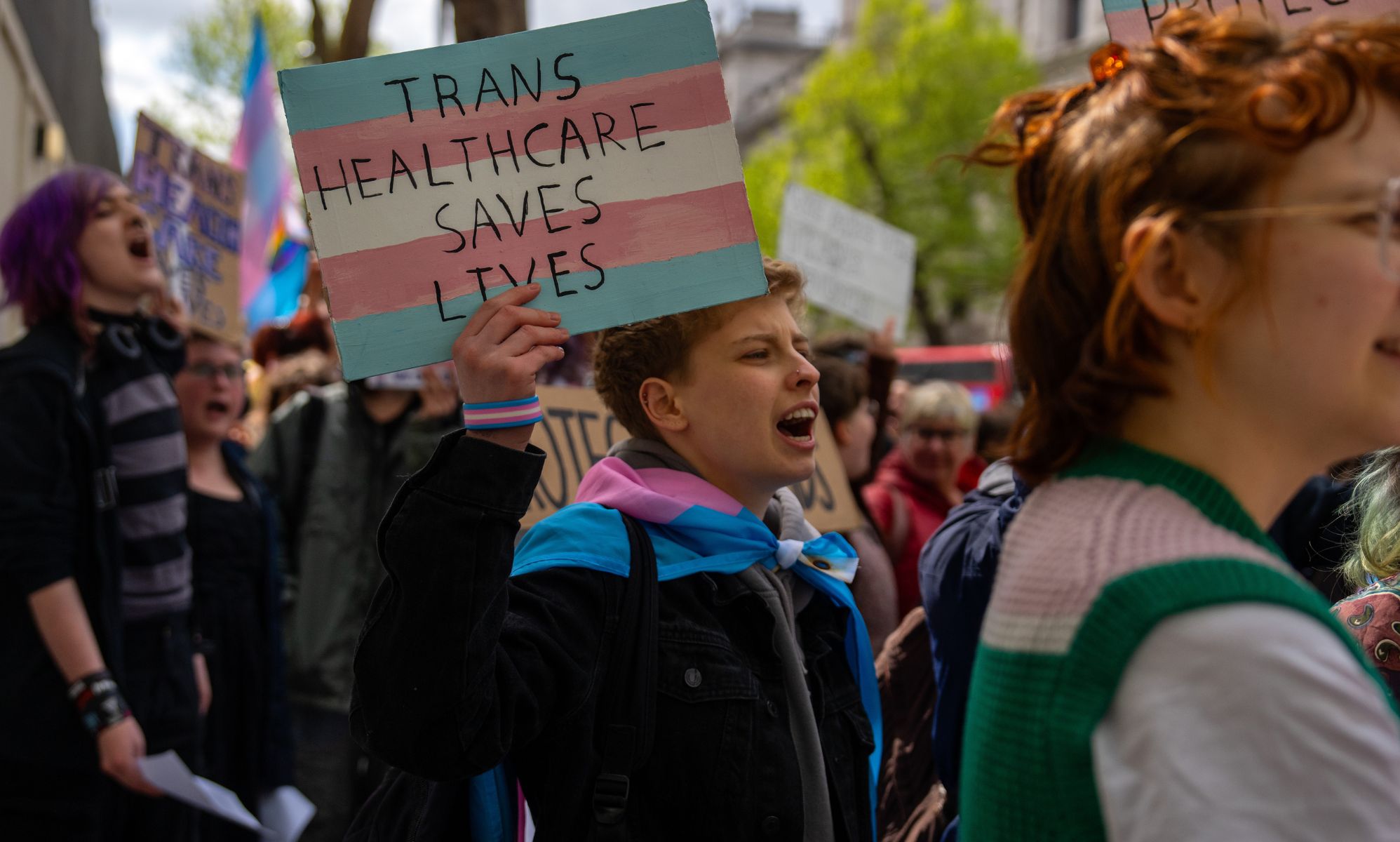 Protestors holding signs that read