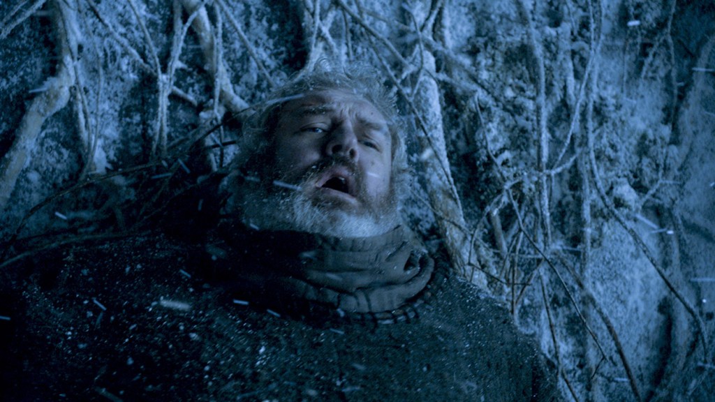 Game of Thrones Still: Kristian Nairn como Hodor en el invierno nevado enredado en las raíces de un árbol