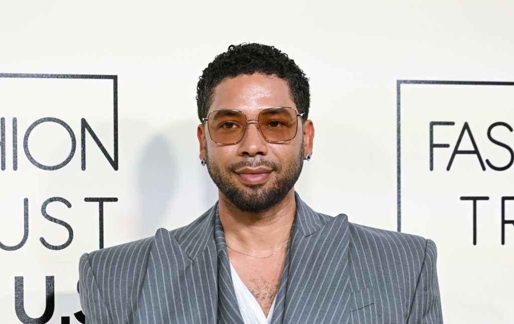 Jussie Smollett in a grey pinstruoe suit. He