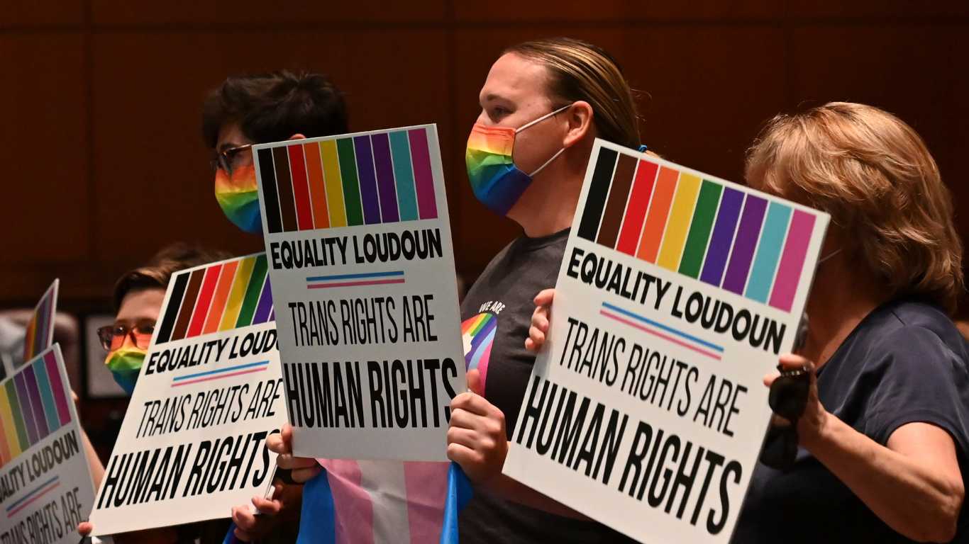 Supporters of Policy 8040 celebrate with signs as the transgender protection measures were voted into the school systems policies during a school board meeting at the Loudoun County Public Schools Administration Building on 11 August, 2021.