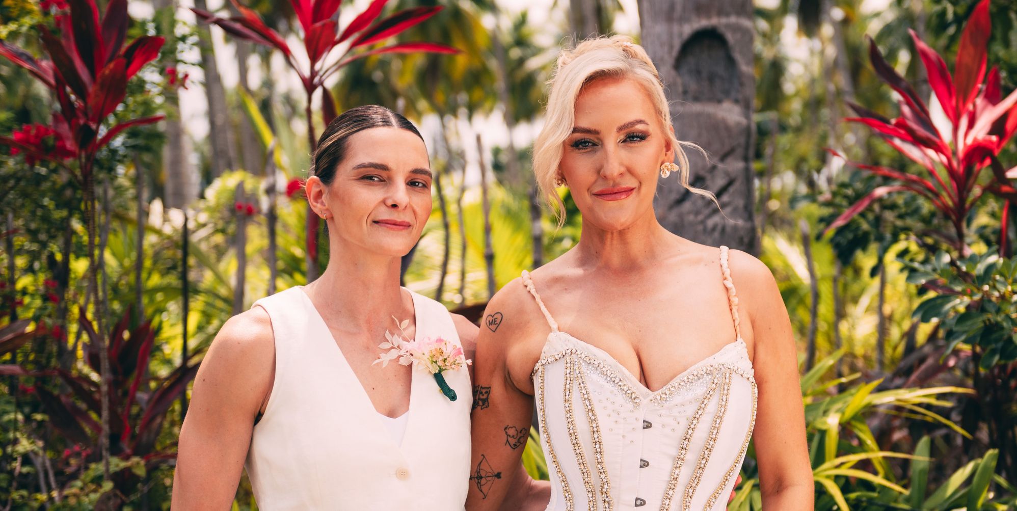 Abby and Helen in their wedding outfits in a promo photo for Stranded on Honeymoon Island