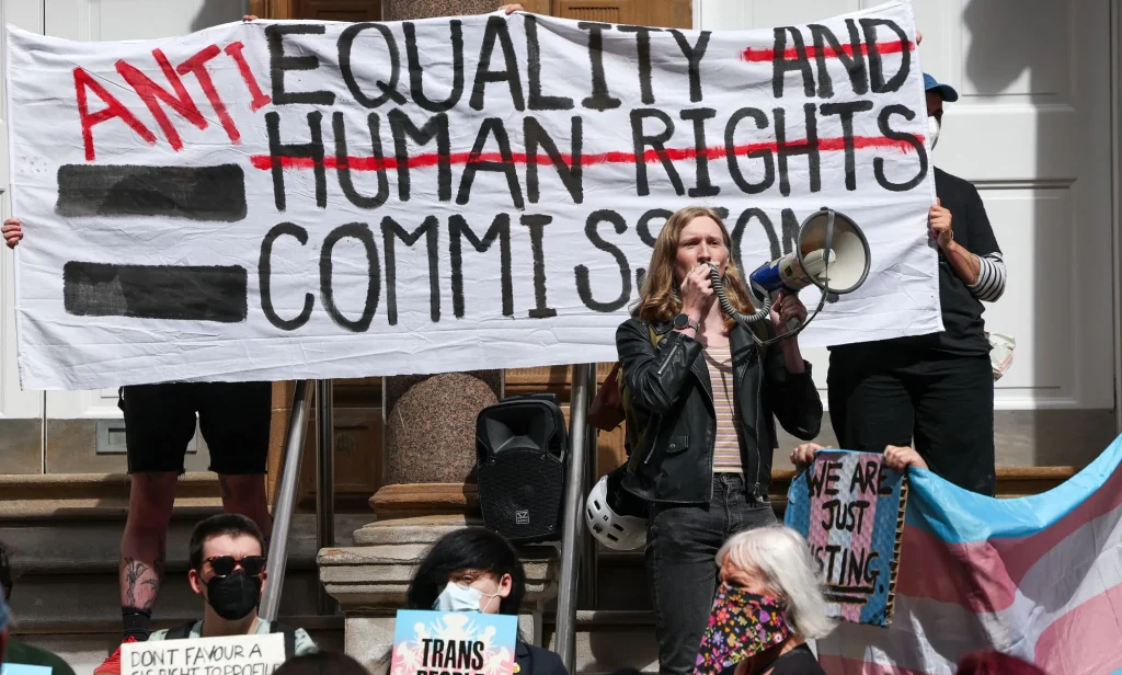 Protestors holding a sign during a trans rights rally.