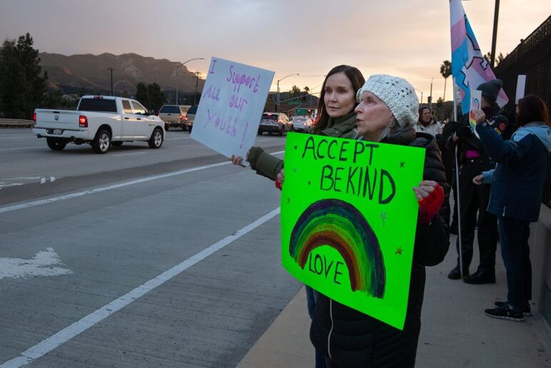 Gayle Casey, a la derecha, y Pauline Campbell, de Newbury Park, mantienen señales en apoyo de LGBTQ+ en el paso elevado de Wendy Drive de la autopista 101 cuando se unieron a un grupo de lugareños que protestaron por la visita de Charlie Kirk a la Capilla del Calvario Godspeak el lunes 30 de enero de 2023.