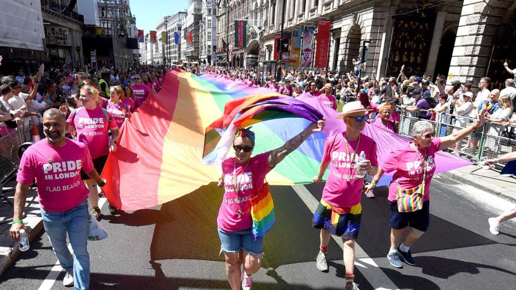 The rainbow flag is carried along Piccadilly by parade-goers during the 2024 Pride In London parade.