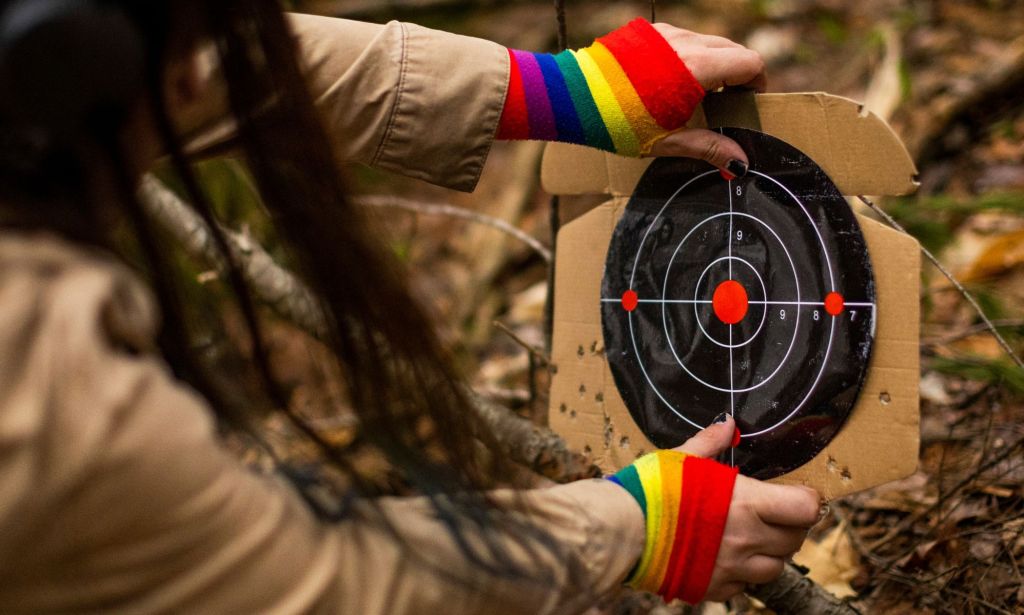 Una persona con guantes de arco iris colocando un objetivo.
