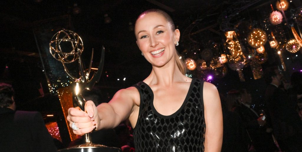 Erin Doherty smiles as she holds out her Emmy Award.