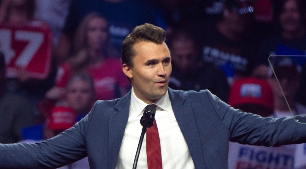 El fundador de Turning Point US, Charlie Kirk, habla durante una manifestación de campaña para el candidato presidencial republicano, el ex presidente de los Estados Unidos, Donald Trump, de pie en el podio con los brazos abiertos