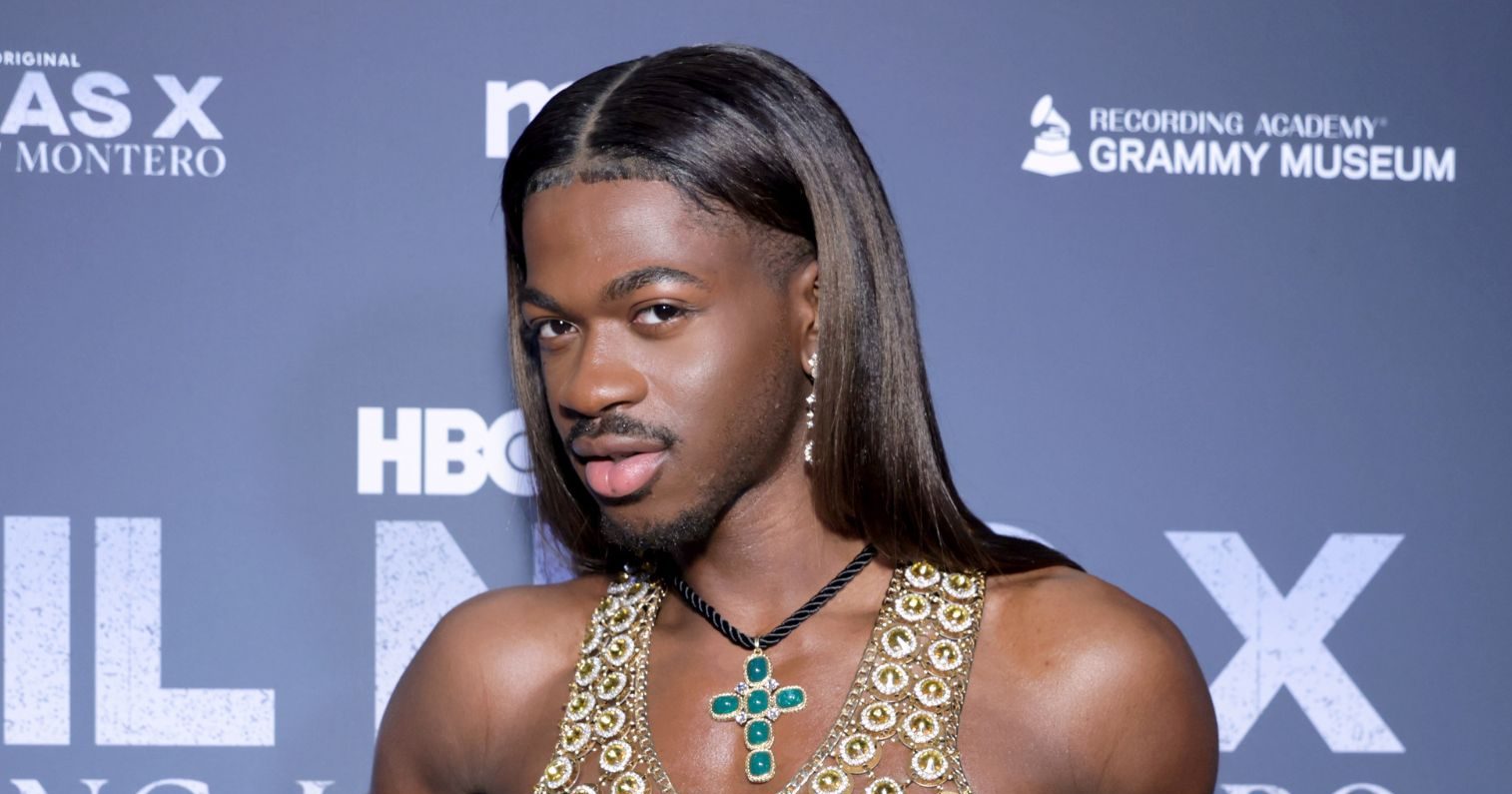 Lil Nas X poses on a red carpet in 2024.