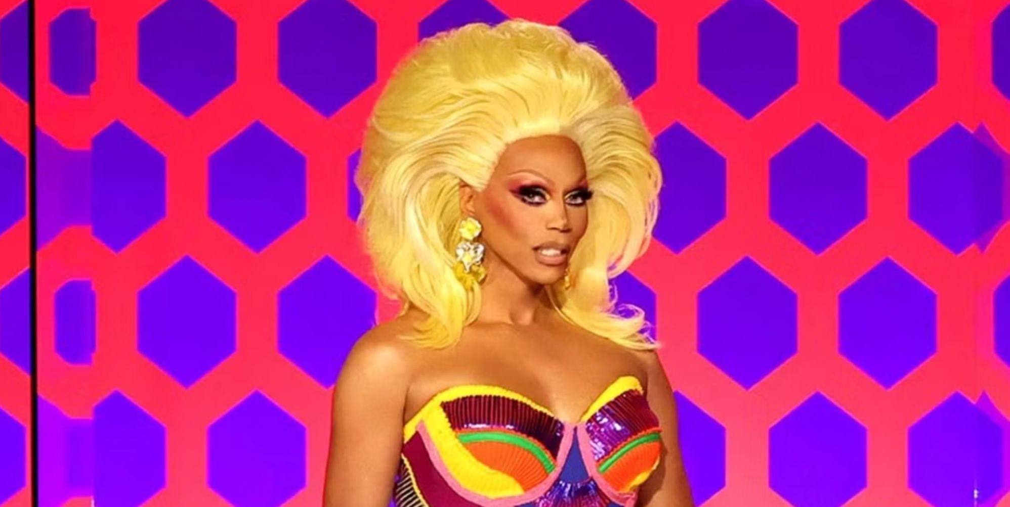 RuPaul smiling on the Drag Race judging panel.