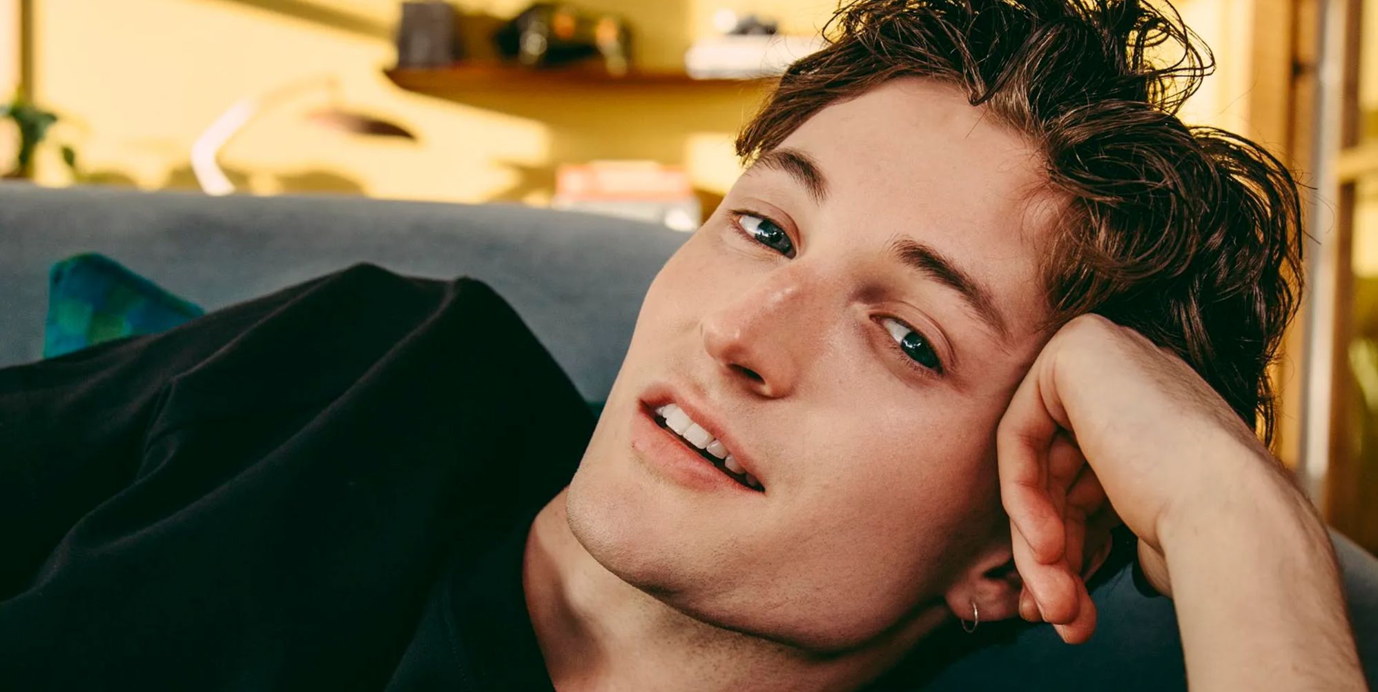 Henry Moodie poses with his head resting on his hand.
