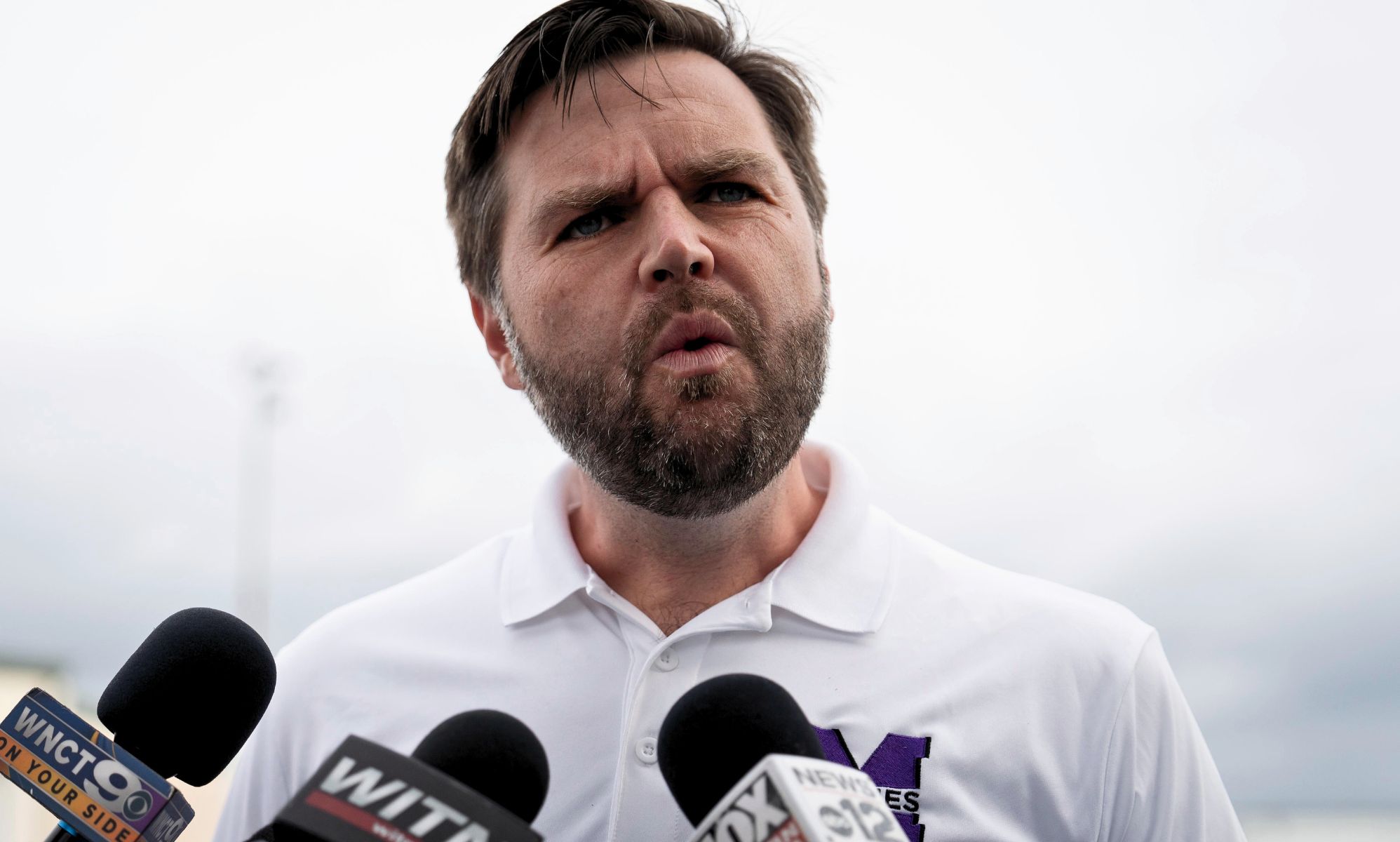 JD Vance, pictured speaking into a set of microphones.