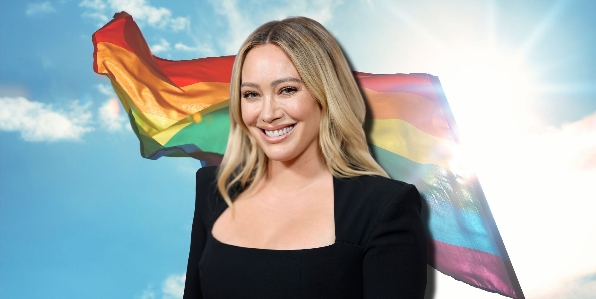 Hilary Duff smiles wearing a black top, imposed against a rainbow flag billowing in the sky.