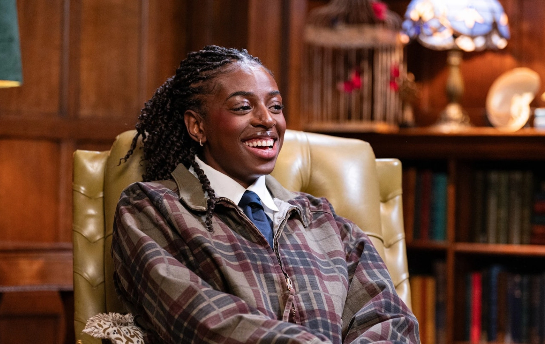 Cat Burns wearing a white shirt, blue tie and a brown chequered jacet on The Celebrity Traitors