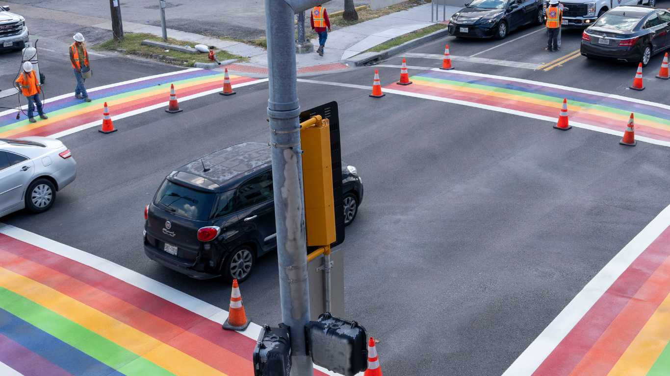 Workers are seen while cars pass along Westheimer.