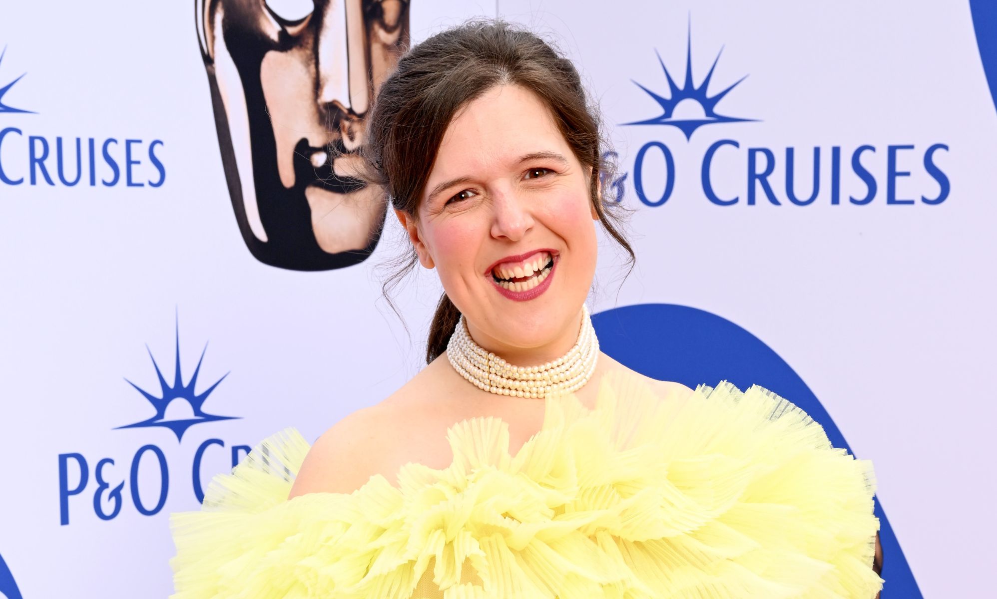 Rosie Jones in a puffy yellow dress at the BAFTA red carpet.