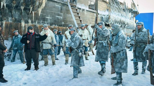 FRANKENSTEIN. (De izquierda a derecha) El escritor/director Guillermo del Toro Lars Mikkelsen como el Capitán Anderson, Nikolaj Lie Kaas como Director General con miembros del elenco en el set de Frankenstein. Cr. Ken Woroner/Netflix © 2025.