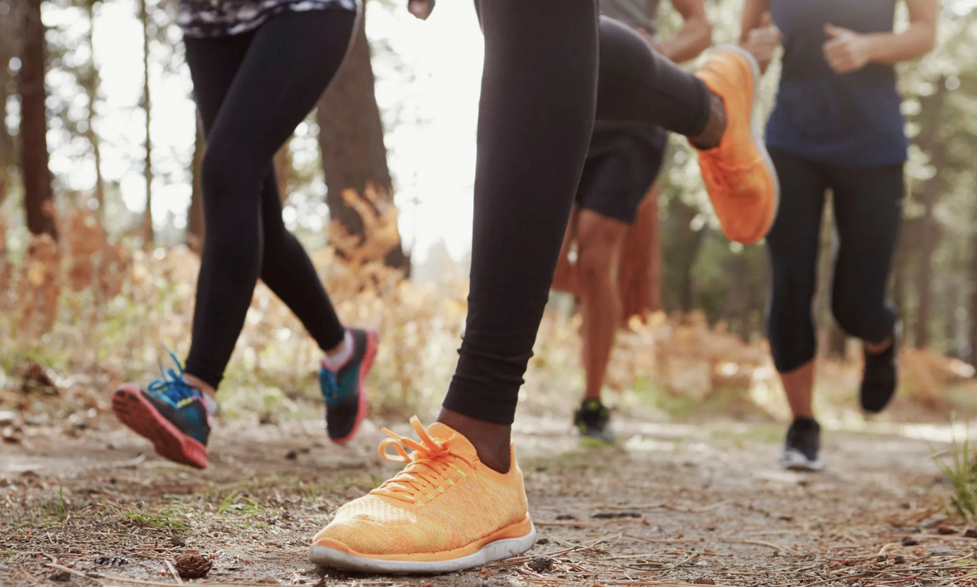 A photo of the lower torsos of a group of runners.
