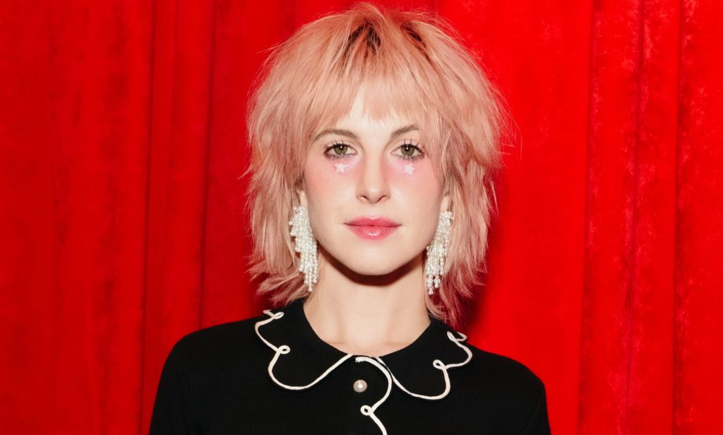 A picture of Hayley Williams in front of a red background.