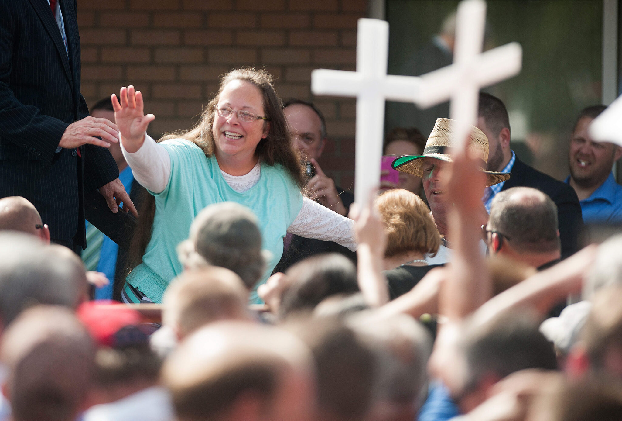 La secretaria de los tribunales del condado de Rowan, Kim Davis, saluda a una multitud de sus partidarios en una manifestación frente al centro de detención del condado de Carter el 8 de septiembre de 2015 en Grayson, Kentucky. A Davis se le ordenó ir a prisión la semana pasada por desacato al tribunal después de rechazar una orden judicial para emitir licencias de matrimonio a parejas del mismo sexo.