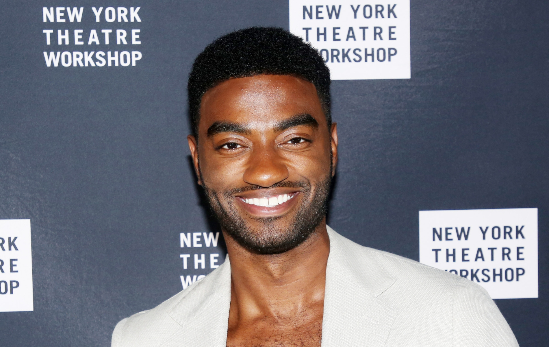 Jelani Alladin posing in a cream suit