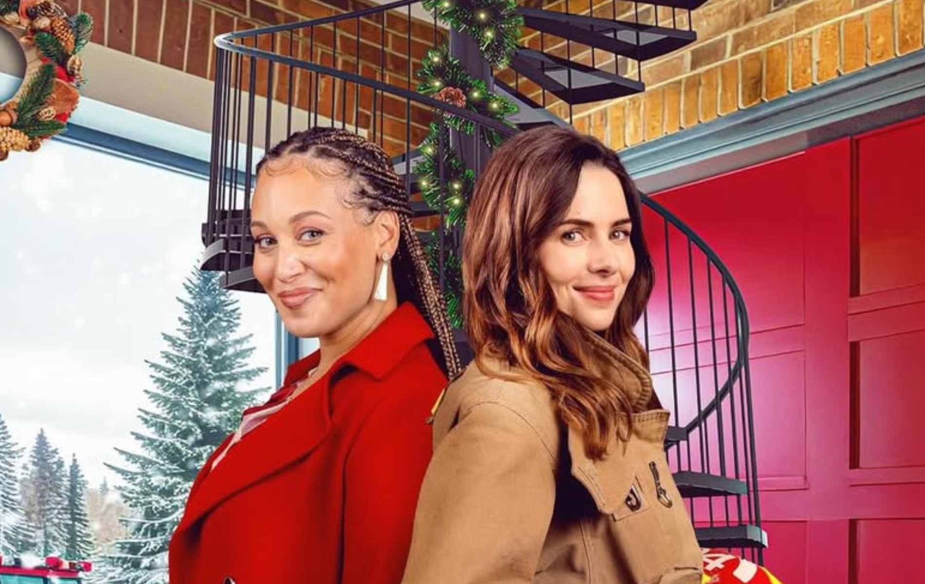 Two women stood back to back in a christmas decorated firefighter station