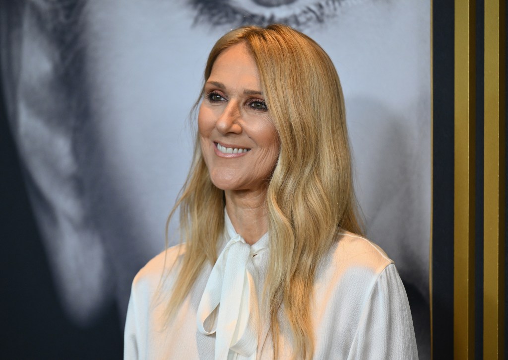 Celine Dion sonriendo con una camisa blanca