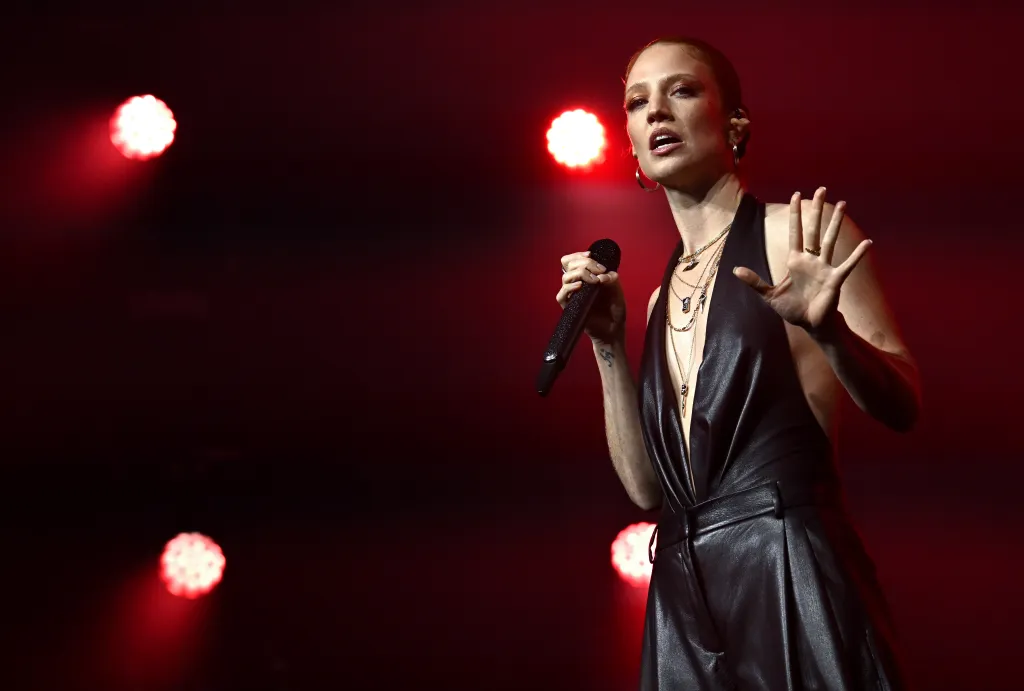 Jess Glynne en el escenario con un look de cuello halter de cuero completamente negro