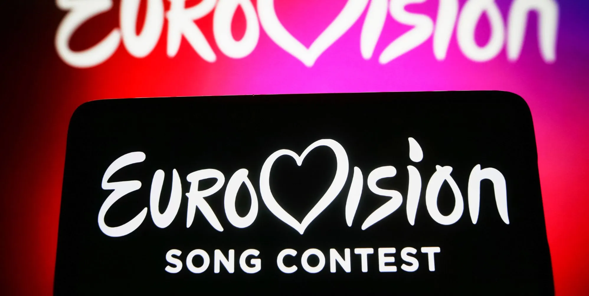 Eurovision Song Contest (ESC) logo is seen on a smartphone and on a pc screen.