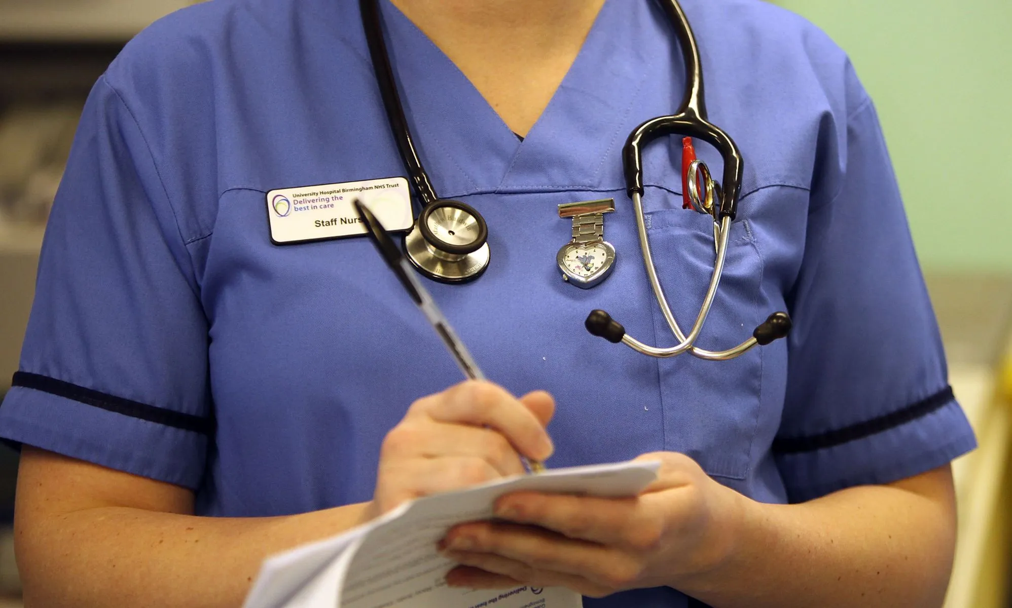 A nurse writing on a document.