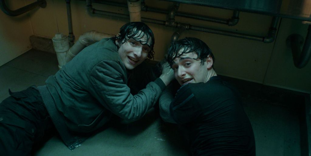 Finn Wolfhard y Noah Schnapp en el piso de un baño en la quinta temporada de Stranger Things.