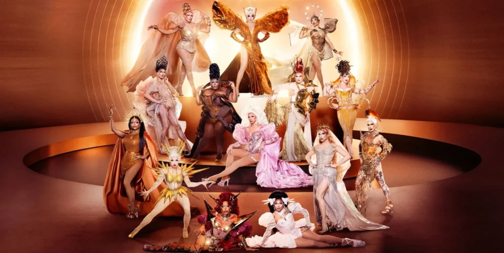 The promotional photo for Drag Race season 18 featuring 14 queens posing in various shades of gold and orange.