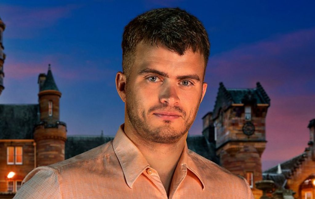 Matthew stood in front of The Traitors castle in a light pink shirt