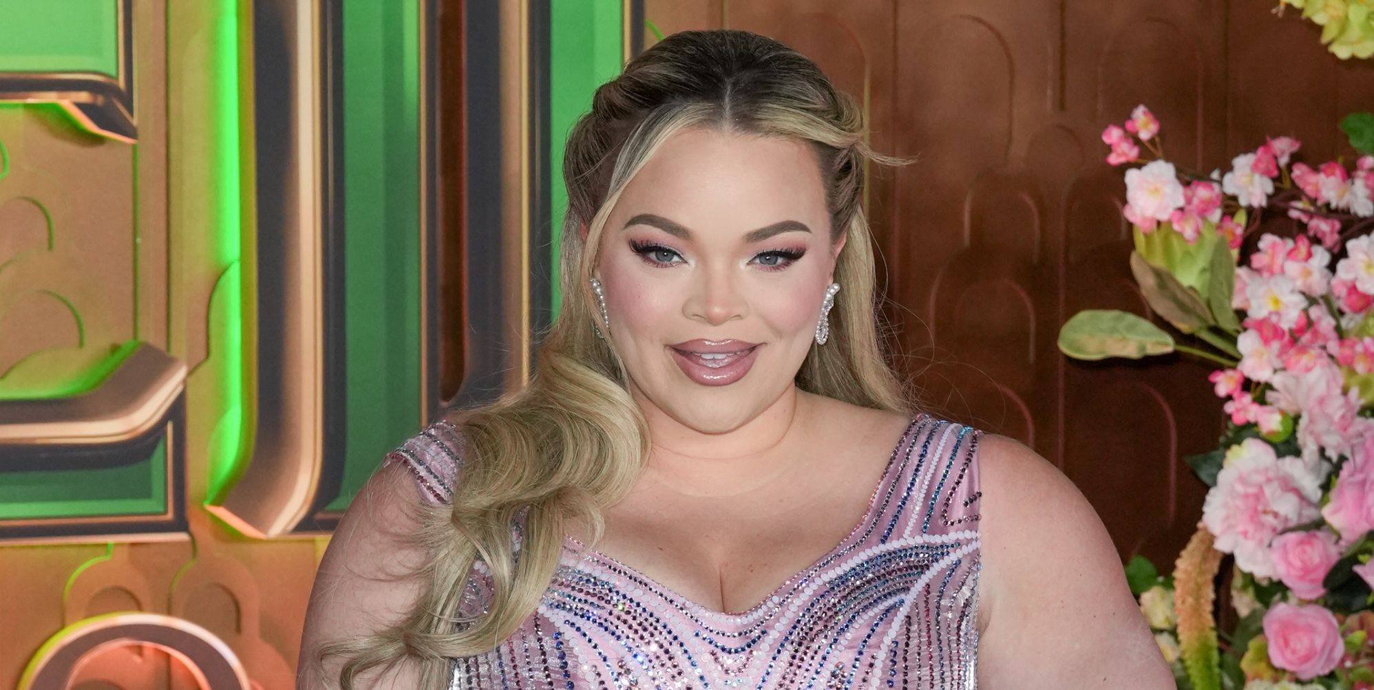 Trisha Paytas smiles while wearing a pink gown on the Wicked red carpet.